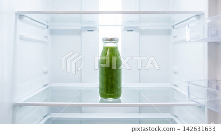 Minimalist diet concept showing a single bottle of fresh green smoothie on a glass shelf inside a stark white fridge for health and wellness branding Minimalist diet concept showing a single bottle of fresh green smoothie on a glass shelf inside a stark white fridge for health and wellness branding 142631633