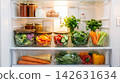 Domestic lifestyle aesthetic showing neatly organized glass bowls of healthy vegetables inside a bright warm fridge for family nutrition marketing 142631634