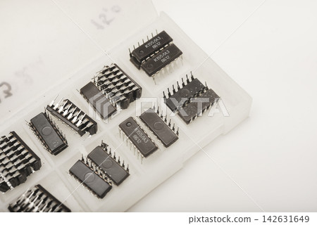 A case for microchips. A plastic container with electronic chips. Microchips in a DIP package. A case for microchips. A plastic container with electronic chips. Microchips in a DIP package. 142631649