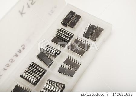 A case for microchips. A plastic container with electronic chips. Microchips in a DIP package. A case for microchips. A plastic container with electronic chips. Microchips in a DIP package. 142631652
