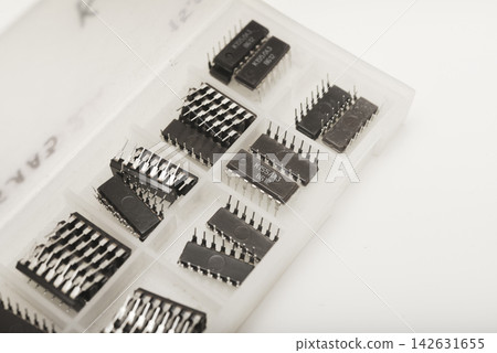 A case for microchips. A plastic container with electronic chips. Microchips in a DIP package. A case for microchips. A plastic container with electronic chips. Microchips in a DIP package. 142631655