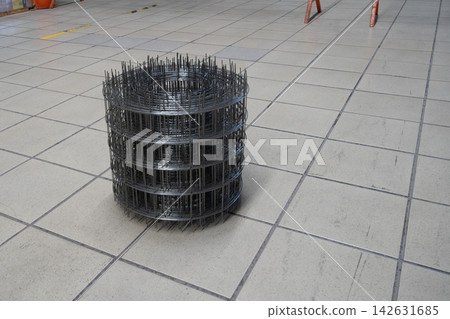 Metal wire mesh used in construction placed on a tiled floor at a building site during day time Metal wire mesh used in construction placed on a tiled floor at a building site during day time 142631685