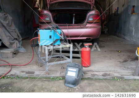 Car repairs are carried out in a garage with tools and equipment designed for welding Car repairs are carried out in a garage with tools and equipment designed for welding 142631690