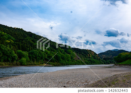 鬱鬱蔥蔥的青山和潺潺流淌的河流構成了一幅美麗的風景。 142632443