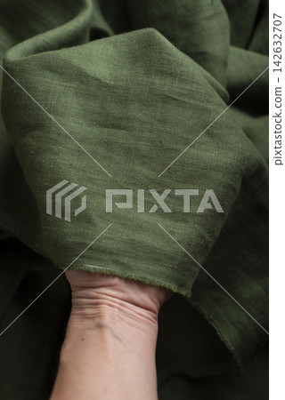 Hand Holding Olive Green Linen Fabric Edge 142632707