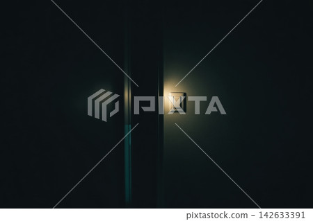 Light switch glowing softly in a dark hallway at night Light switch glowing softly in a dark hallway at night 142633391