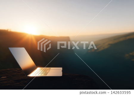 Sleek laptop placed on a rocky ledge during sunset over a scenic cliff Sleek laptop placed on a rocky ledge during sunset over a scenic cliff 142633595