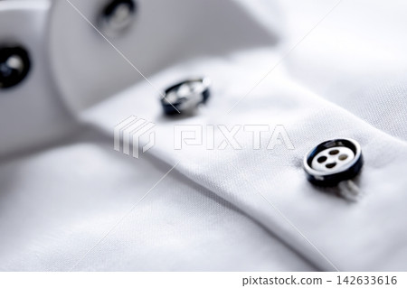 Close-up view of a shirt placket with contrasting buttons in soft fabric 142633616