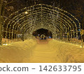 Illuminations on a snow-covered sidewalk 142633795