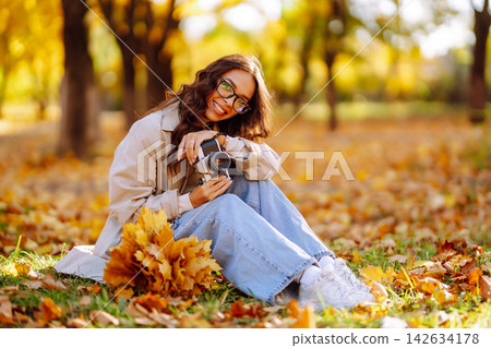 Beautiful woman taking pictures in the autumn forest. Rest, relaxation, tourism, lifestyle concept. Beautiful woman taking pictures in the autumn forest. Rest, relaxation, tourism, lifestyle concept. 142634178