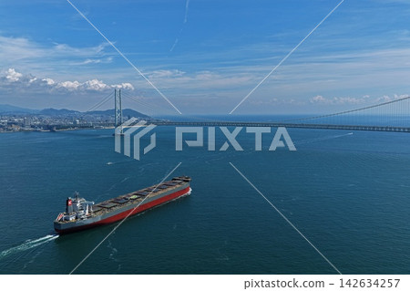 Aerial photograph of the Akashi Kaikyo Bridge and a cargo ship in Awaji City, Hyogo Prefecture. Aerial photograph of the Akashi Kaikyo Bridge and a cargo ship in Awaji City, Hyogo Prefecture. 142634257