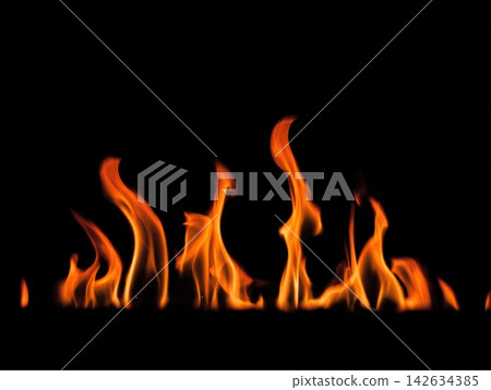 Fire flames dance against a clean black background creating a warm glow Fire flames dance against a clean black background creating a warm glow 142634385