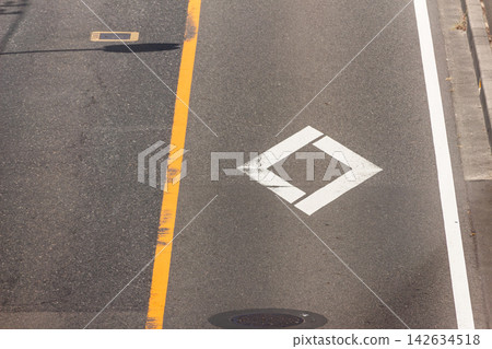 Asphalt road with diamond markings and road surface markings just before a pedestrian crossing, photographed from a high angle. Asphalt road with diamond markings and road surface markings just before a pedestrian crossing, photographed from a high angle. 142634518