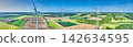 Wind turbines across green farmland in a renewable energy landscape 142634595
