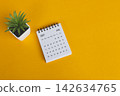 The July 2027 desk calendar with potted plant on yellow background. 142634765