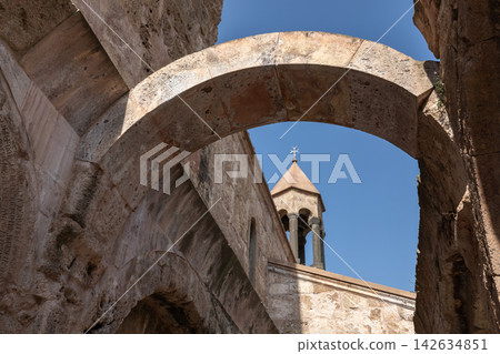 Ancient stone monastery bell tower seen through weathered arches Ancient stone monastery bell tower seen through weathered arches 142634851