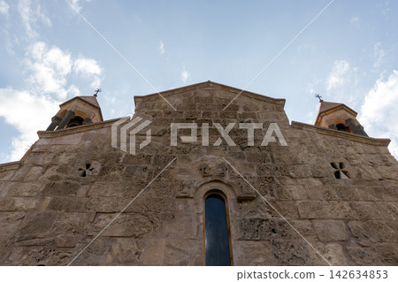 Historic stone church facade featuring a narrow arched window Historic stone church facade featuring a narrow arched window 142634853