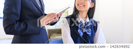 校園生活場景:一名女學生和她的老師正在用平板電腦互相溝通。 校園生活場景:一名女學生和她的老師正在用平板電腦互相溝通。 142634892