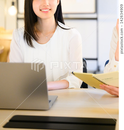 一位女士正在工作,一邊看著她的筆記型電腦和文件。 一位女士正在工作,一邊看著她的筆記型電腦和文件。 142634909