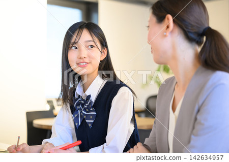 一名女學生正在學習,同時接受女老師的指導。 一名女學生正在學習,同時接受女老師的指導。 142634957