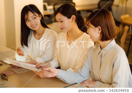 三位女士在會議上分享文件 三位女士在會議上分享文件 142634958