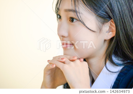 一位年輕的女商務人士手托著下巴,面帶微笑。 一位年輕的女商務人士手托著下巴,面帶微笑。 142634973