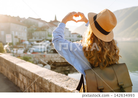 Happy young woman showing heart shaped hands. Love of travel. Happy young woman showing heart shaped hands. Love of travel. 142634993