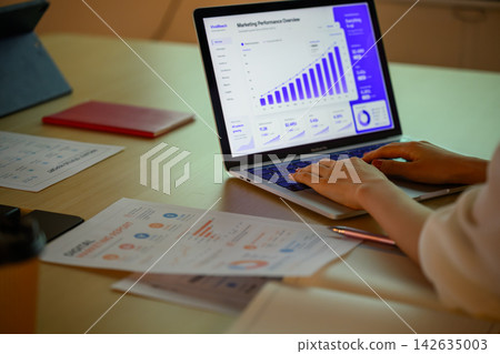 Analyzing marketing data on a laptop computer Analyzing marketing data on a laptop computer 142635003
