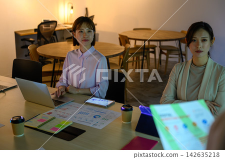 Two women operating a PC and a tablet in a conference room. Two women operating a PC and a tablet in a conference room. 142635218