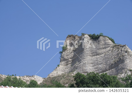 White Limestone Rock Formation Against a Deep Blue Summer Sky 142635321