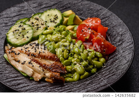 An Asian style bowl with eel, edamame, avocado, tomatoes, and lettuce. A eel and vegetable bowl An Asian style bowl with eel, edamame, avocado, tomatoes, and lettuce. A eel and vegetable bowl 142635682