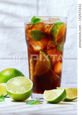 Refreshing soft drink, with cola, lime and mint, on a marble surface, sunlight, no people, Refreshing soft drink, with cola, lime and mint, on a marble surface, sunlight, no people, 142635832