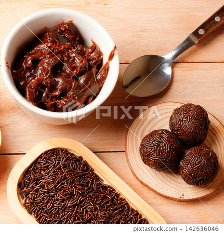 Traditional Brazilian chocolate brigadeiro coated in sprinkles, on a bamboo tray atop a wooden table. Traditional Brazilian chocolate brigadeiro coated in sprinkles, on a bamboo tray atop a wooden table. 142636046