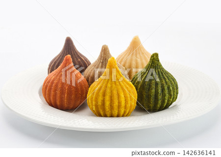 Assorted modak, a popular indian sweet, on a white plate Assorted modak, a popular indian sweet, on a white plate 142636141
