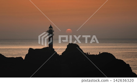 Punta de Teno lighthouse silhouette in Tenerife, with Atlantic Ocean view under colorful evening sky. Drone flight panorama. Canary Islands: Tourists enjoy vibrant orange sunset landscape Punta de Teno lighthouse silhouette in Tenerife, with Atlantic Ocean view under colorful evening sky. Drone flight panorama. Canary Islands: Tourists enjoy vibrant orange sunset landscape 142636320