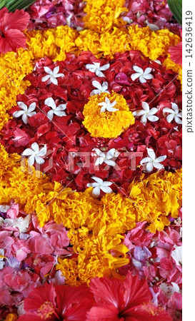 Colorful flower arrangement forms geometric pattern with red petals, yellow marigolds, and white blossoms, creating vivid decorative design. Floral arrangement fills frame with layered texture Colorful flower arrangement forms geometric pattern with red petals, yellow marigolds, and white blossoms, creating vivid decorative design. Floral arrangement fills frame with layered texture 142636419