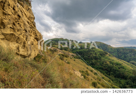 Majestic rocky cliffs and towering trees against blue sky. View of the rocks in Kislovodsk, Russia. Majestic rocky cliffs and towering trees against blue sky. View of the rocks in Kislovodsk, Russia. 142636773