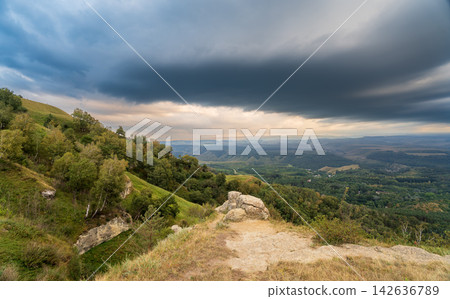 A mountain range covered in the wild woods illuminated by the golden light of the setting sun. A natural Park reserve or hunting grounds. Recreational outdoor tourism A mountain range covered in the wild woods illuminated by the golden light of the setting sun. A natural Park reserve or hunting grounds. Recreational outdoor tourism 142636789
