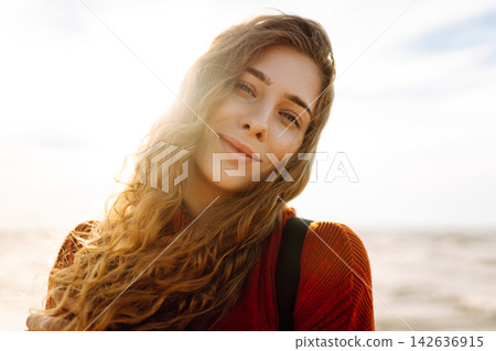 Young woman walking along sea at sunset. Travel, weekend, relax and lifestyle concept. Young woman walking along sea at sunset. Travel, weekend, relax and lifestyle concept. 142636915