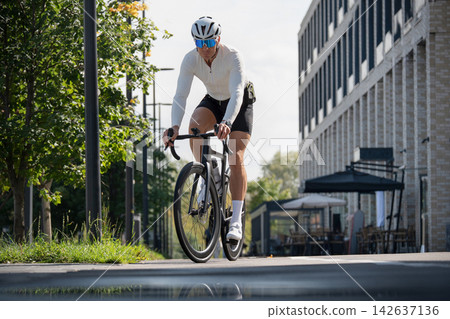 Road cyclist riding bicycle on urban street Road cyclist riding bicycle on urban street 142637136
