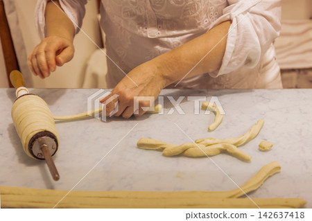 Woman preparing dough with rolling pin on kitchen countertop for baking Woman preparing dough with rolling pin on kitchen countertop for baking 142637418
