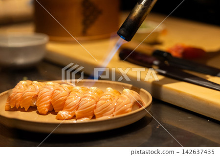 Sushi preparation with blowtorch highlighting culinary artistry and technique Sushi preparation with blowtorch highlighting culinary artistry and technique 142637435