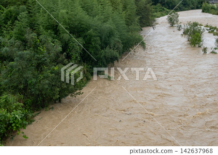 暴雨過後,渾濁的河水湍急。 暴雨過後,渾濁的河水湍急。 142637968