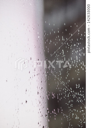 Raindrops on window screen mesh with soft light contrast and bokeh Raindrops on window screen mesh with soft light contrast and bokeh 142638000