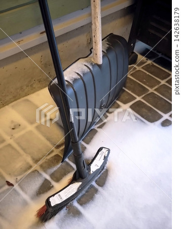Snow shovel and brush on a snow-covered porch Snow shovel and brush on a snow-covered porch 142638179