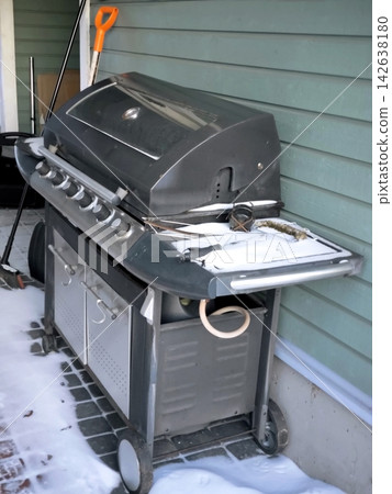 Gas barbecue grill on a snow-covered house terrace. Gas barbecue grill on a snow-covered house terrace. 142638180