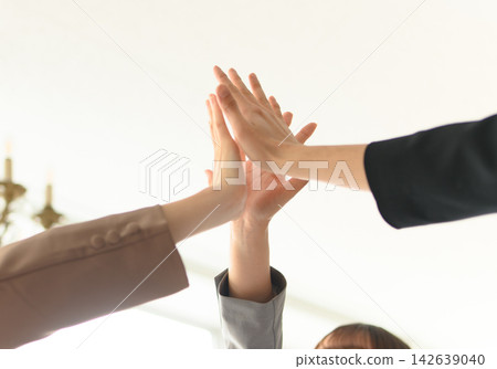 辦公室裡,業務團隊成員互相擊掌慶祝。 辦公室裡,業務團隊成員互相擊掌慶祝。 142639040