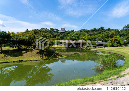 Genkyu-en Garden, a lush, strolling garden with a pond, offers a view of the national treasure Hikone Castle keep across the pond. Genkyu-en Garden, a lush, strolling garden with a pond, offers a view of the national treasure Hikone Castle keep across the pond. 142639422