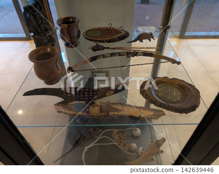 Puerto Iguazu, Argentina - June 24, 2025: Traditional Bow and Wooden Souvenirs Behind Glass Puerto Iguazu, Argentina - June 24, 2025: Traditional Bow and Wooden Souvenirs Behind Glass 142639446