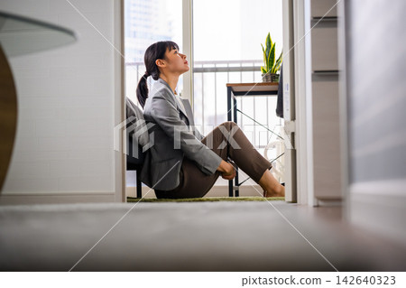 一位疲憊的女商人獨自在房間裡沉思。 142640323